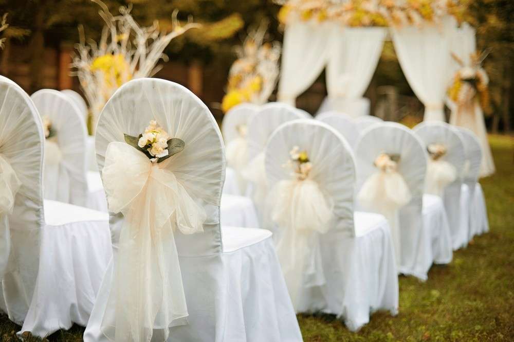 Auch Stuhlhussen mit hübschen Bändern verleihen dem Hochzeitsraum eine zusätzliche festliche Atmosphäre