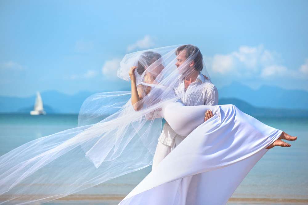 schönes Paar am Strand in Hochzeitskleid